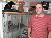 Lars foran sin montre med lækkert merchandise - bemærk Harry Potter-hattene ovenpå montren